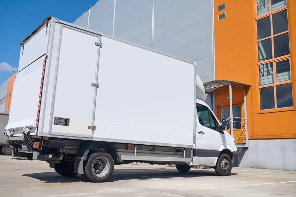A delivery truck at a warehouse loading zone highlights how delivery truck engines provide reliable performance for daily goods transportation and distribution tasks.