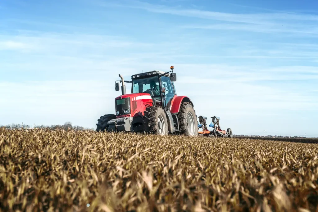 tractor diesel engines powering tractor cultivating large agricultural field