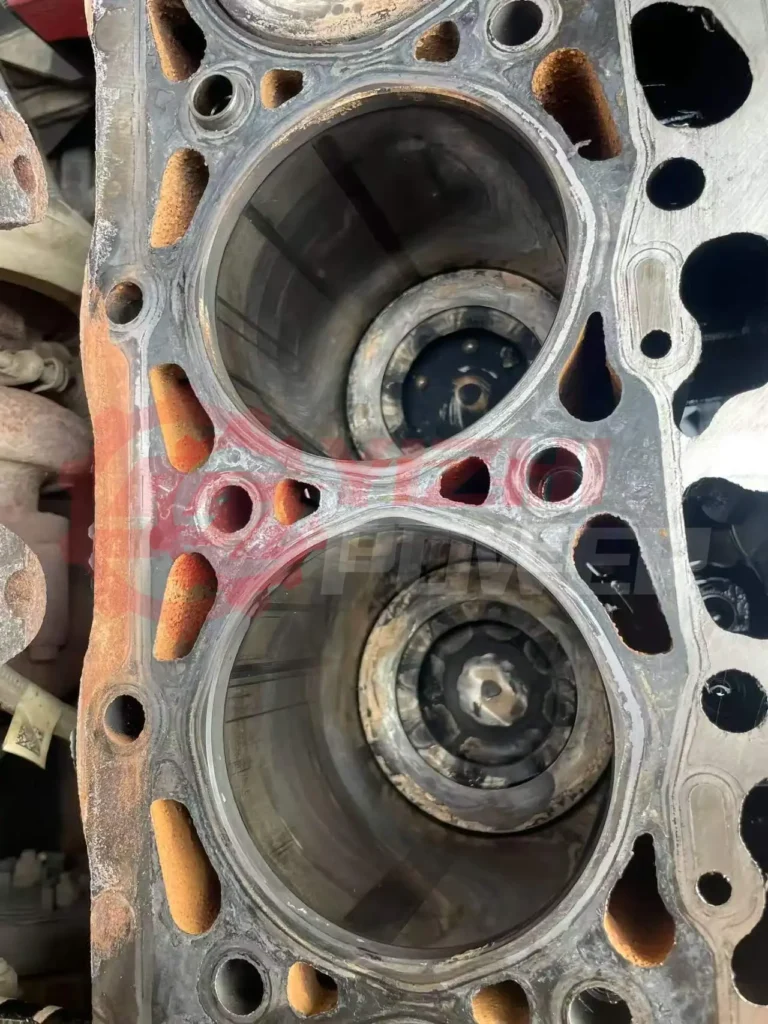 Close-up view of Cummins cylinder head showing fine cracks and localized damage caused by thermal stress