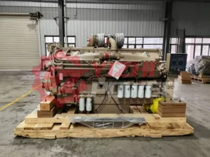 Rear view of Cummins K50 engine assembly showing the official red CCEC logo on the flywheel cover.