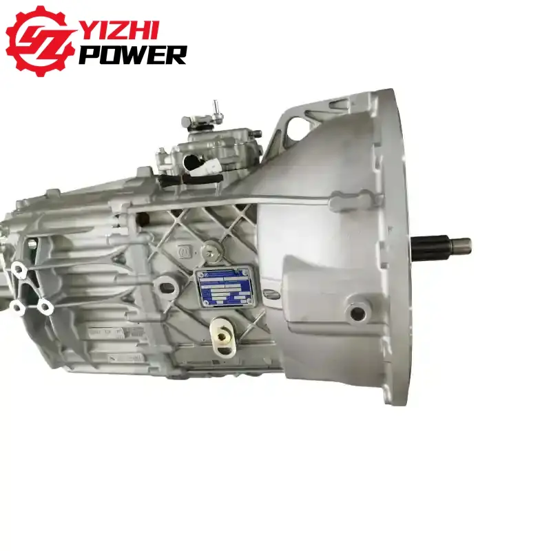 Silver car manual transmission housing with an extended input shaft and a blue data plate; YIZHI POWER logo in the top-left corner.